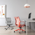 A red full mesh mid-back office chair with an adjustable up-down and back tilting mechanism, chrome gaslift, and white PU castors, positioned in a modern office setting.